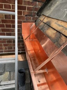 copper gutter installed on a home with a slate roof
