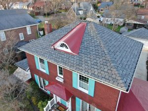 Shingle roof installed on a home with teal shutters and red roof awning