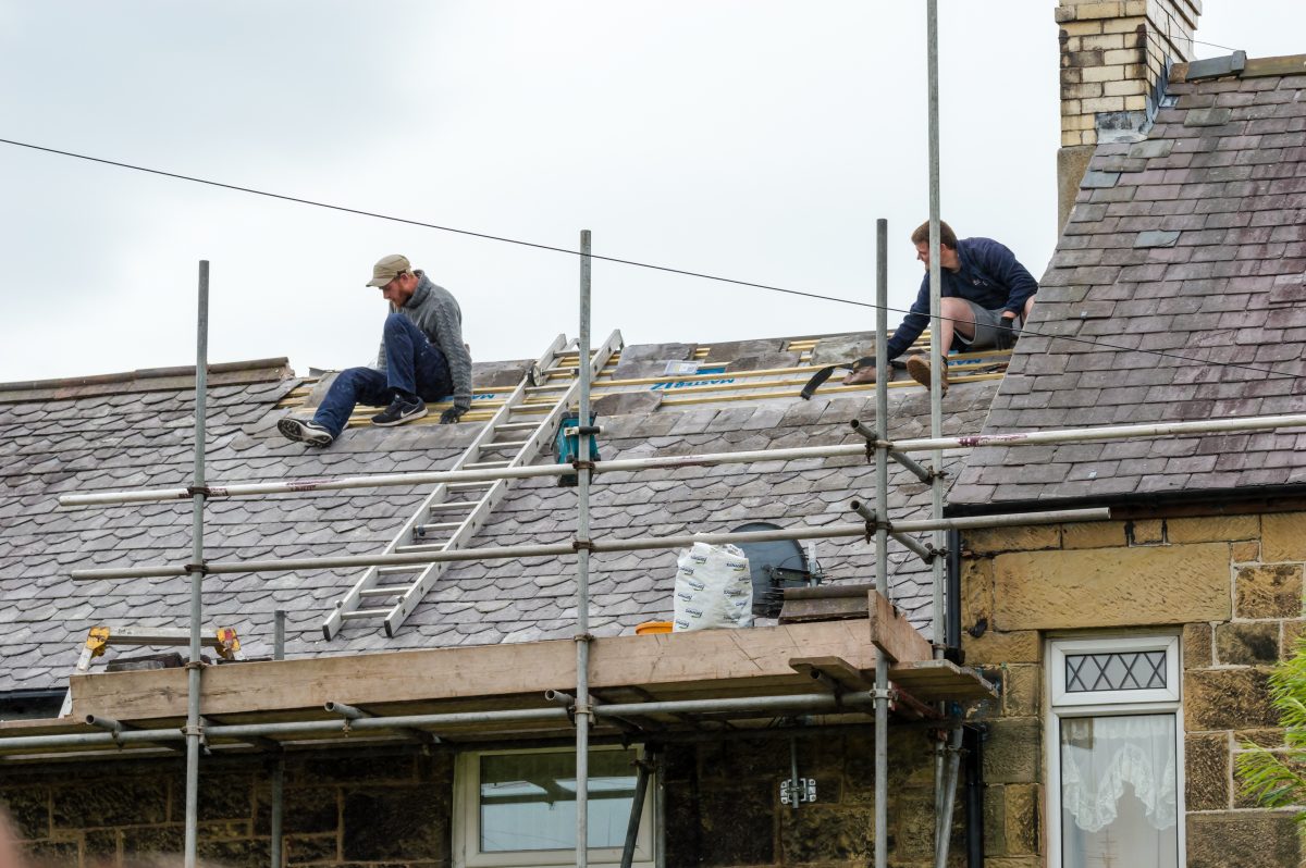 crew installing slate roof after replacing underlayment